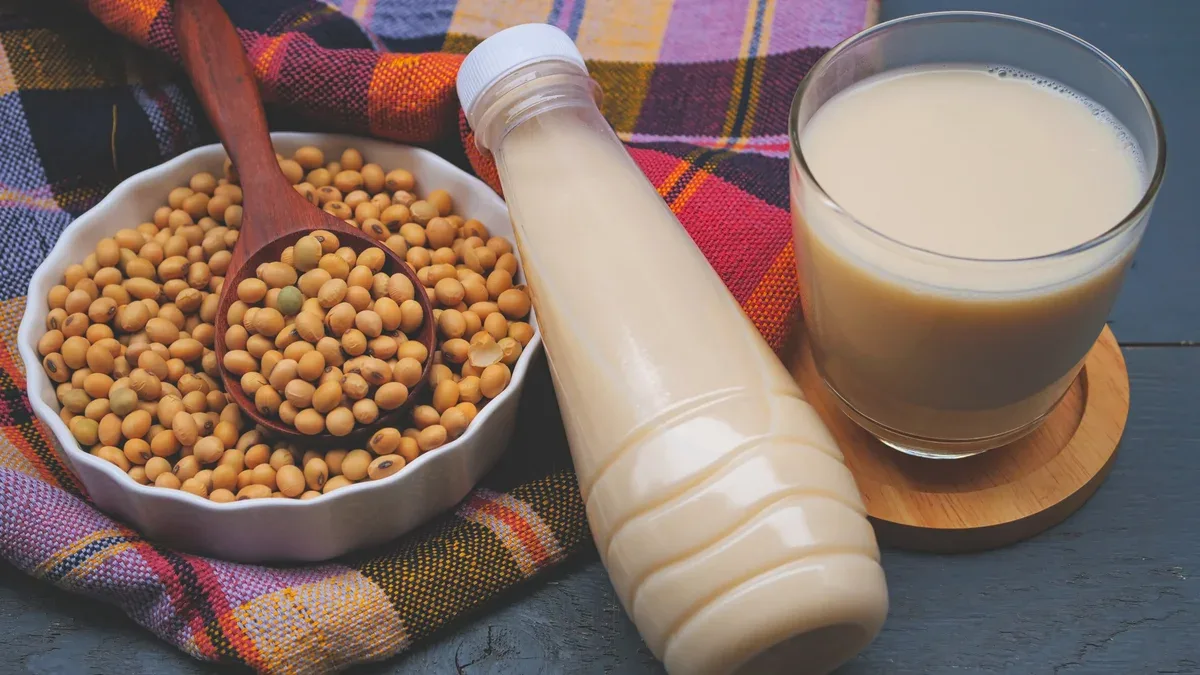 Bouteille de lait de soja et de soja sur table en bois